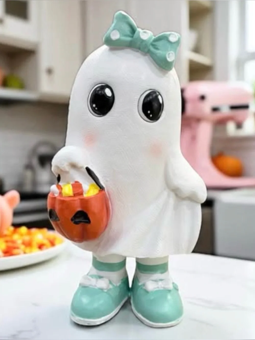 NEW Adorable ghost figurine holding a candy basket. Features teal shoes and bow.